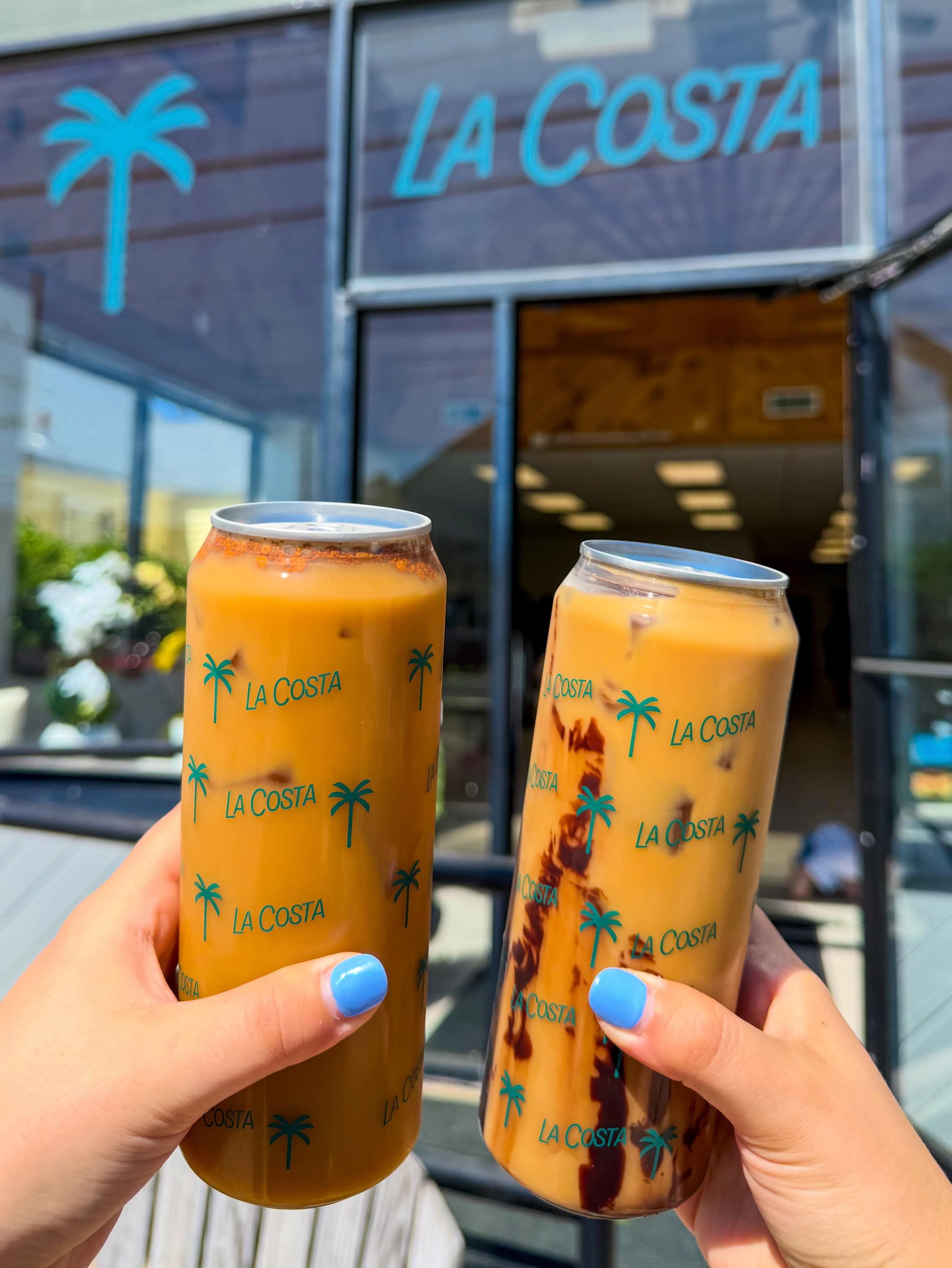 Friends raising La Costa cups outside the shop